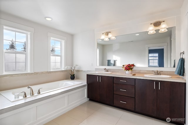 bathroom with vanity, a washtub, and tile patterned floors