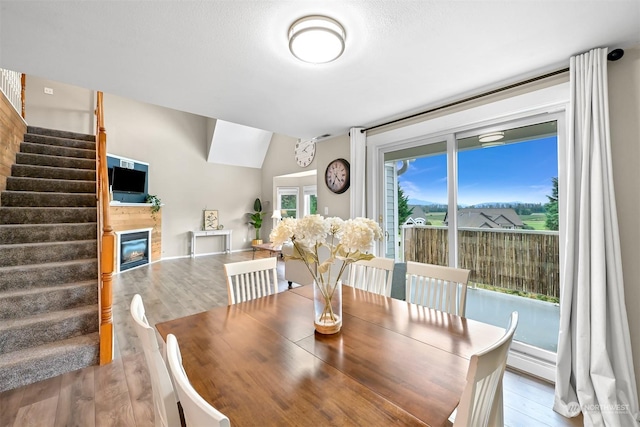 dining room featuring vaulted ceiling and light wood-type flooring