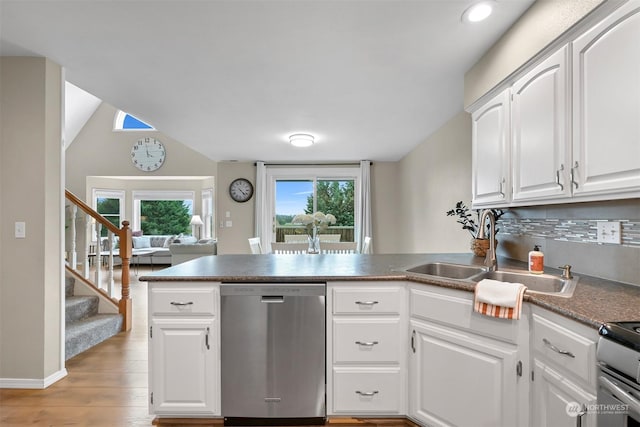 kitchen featuring white cabinetry, stainless steel appliances, kitchen peninsula, and sink