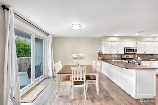 dining space with sink and light wood-type flooring