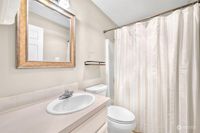 bathroom with walk in shower, vanity, and toilet