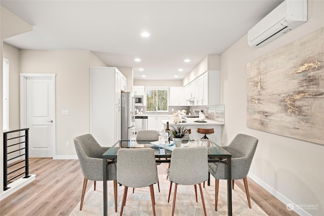 dining area with light hardwood / wood-style floors and an AC wall unit