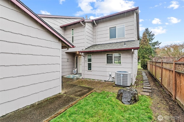 rear view of house with a yard and central AC unit