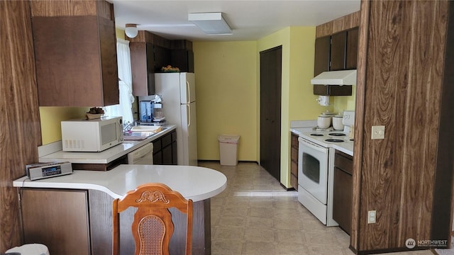 kitchen featuring dark brown cabinetry and white appliances