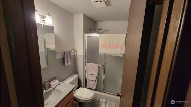 bathroom featuring an enclosed shower, vanity, and toilet