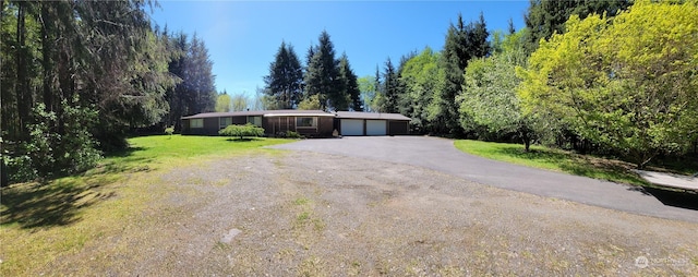 single story home with a garage and a front lawn