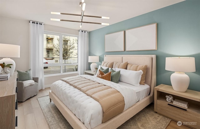 bedroom featuring light hardwood / wood-style flooring and a notable chandelier