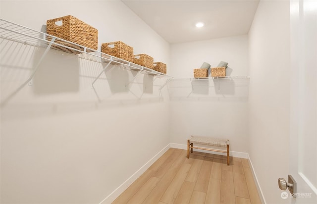 walk in closet with hardwood / wood-style floors