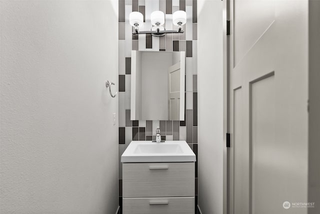 bathroom featuring vanity and backsplash