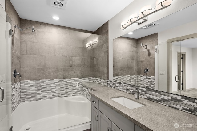 bathroom with vanity, tasteful backsplash, and walk in shower