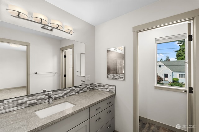 bathroom featuring vanity and backsplash