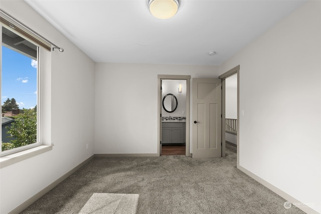 unfurnished bedroom featuring connected bathroom and carpet floors