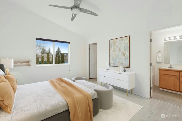 bedroom featuring vaulted ceiling, connected bathroom, sink, ceiling fan, and light hardwood / wood-style floors