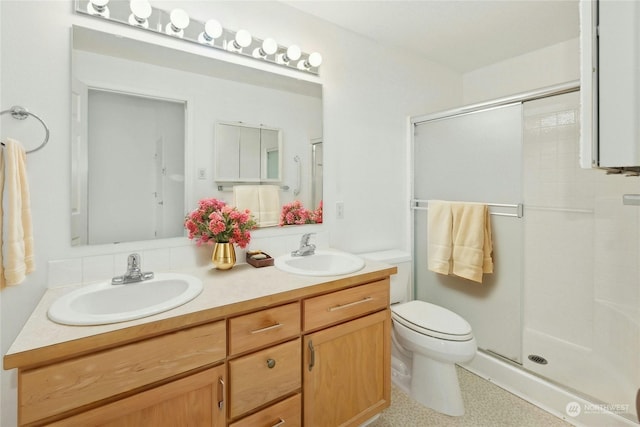 bathroom with vanity, toilet, and a shower with shower door