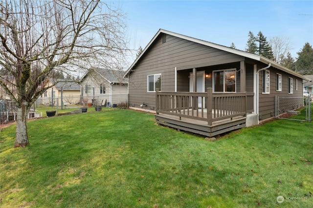 back of house featuring a deck and a lawn