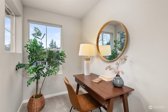 carpeted home office featuring lofted ceiling and plenty of natural light