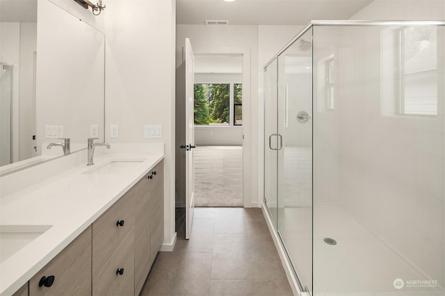 bathroom featuring tile patterned flooring, vanity, and a shower with shower door