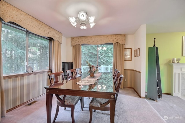 dining area with light colored carpet and a notable chandelier