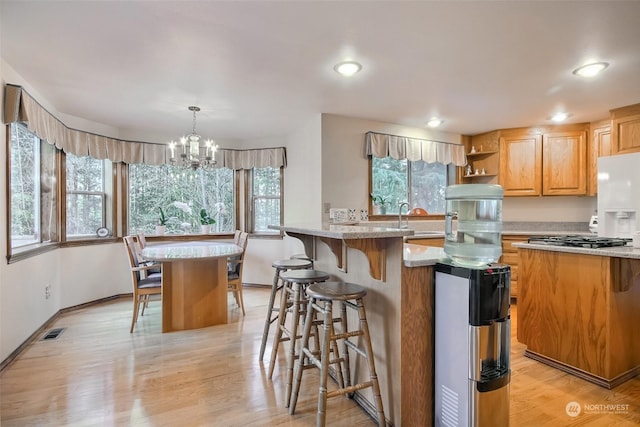 kitchen with pendant lighting, a center island, a breakfast bar area, and light hardwood / wood-style flooring