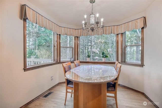 dining space with a chandelier and light wood-type flooring