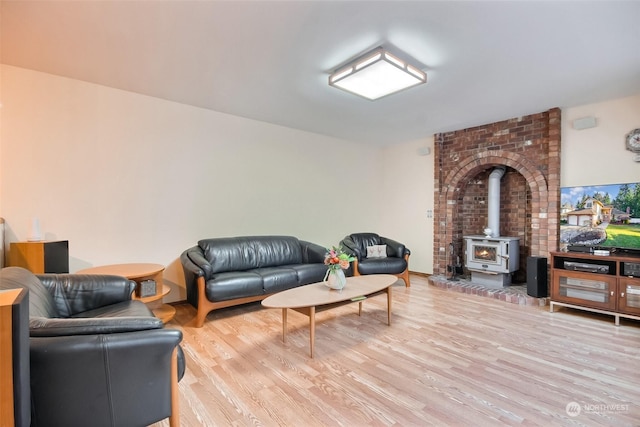 living room featuring a wood stove and light hardwood / wood-style flooring