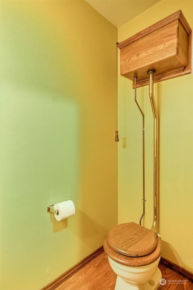 bathroom featuring wood-type flooring and toilet