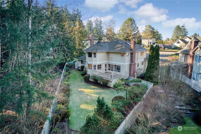 back of house with a balcony and a yard