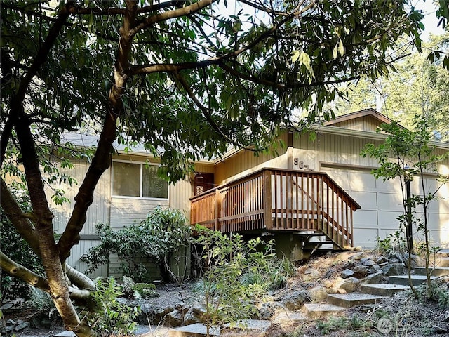 view of side of home featuring a garage and a wooden deck