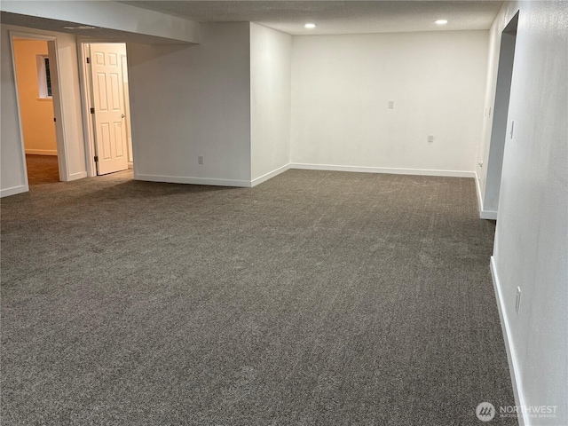 finished below grade area featuring baseboards, dark carpet, and recessed lighting