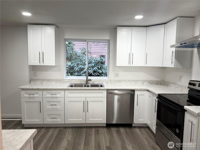 kitchen with dark wood-style flooring, white cabinetry, stainless steel appliances, and a sink