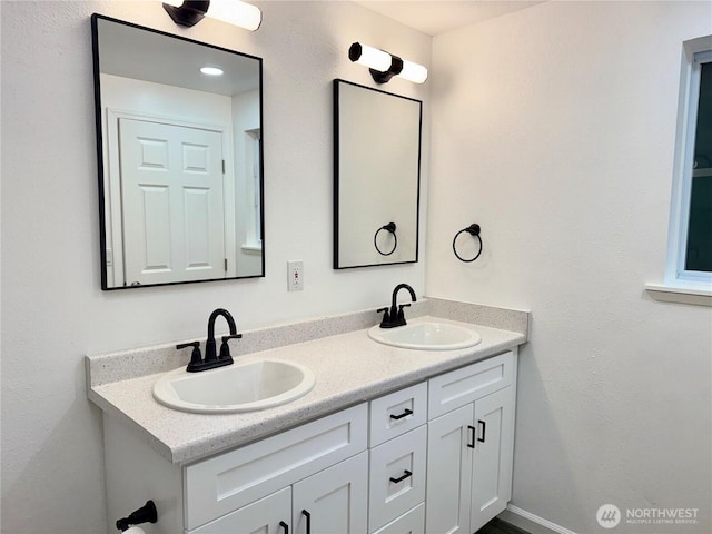 bathroom featuring a sink and double vanity