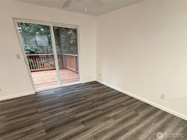 spare room featuring visible vents, dark wood finished floors, baseboards, and ceiling fan