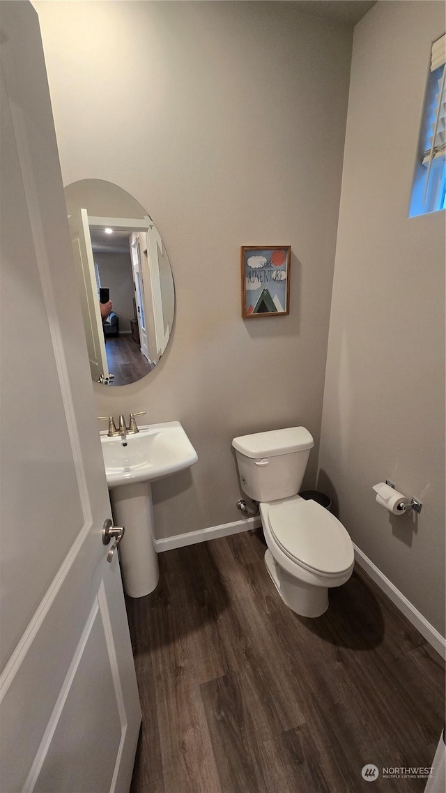 bathroom featuring toilet, baseboards, and wood finished floors