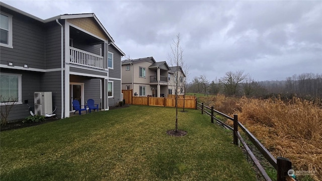 view of yard featuring a balcony and fence