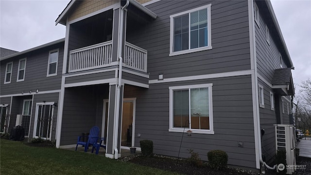 back of house featuring a lawn and a balcony