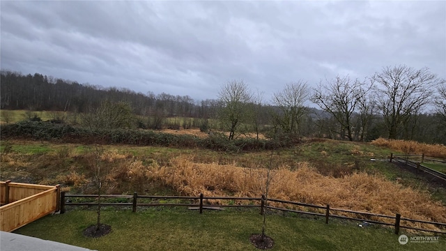 view of yard featuring fence and a view of trees