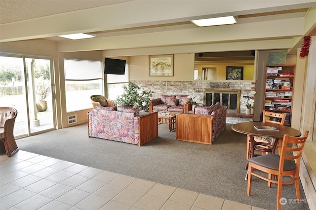 carpeted living room with a brick fireplace and beam ceiling