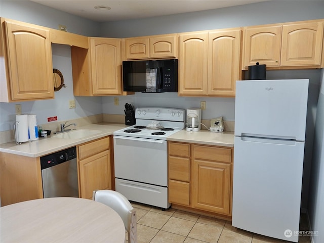 kitchen with sink, light tile patterned floors, light brown cabinetry, and white appliances