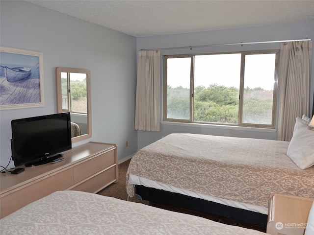 bedroom featuring a textured ceiling and dark colored carpet