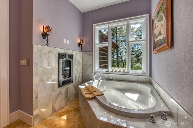 bathroom with a jetted tub and tile walls