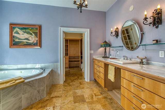 bathroom with a chandelier, a bath, and vanity