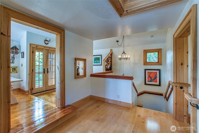 entrance foyer featuring light wood-style flooring, a notable chandelier, and baseboards
