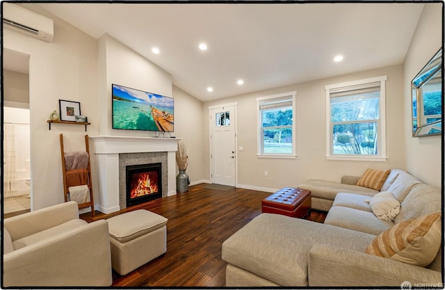 living room with a tile fireplace, vaulted ceiling, a wall mounted AC, and dark hardwood / wood-style flooring