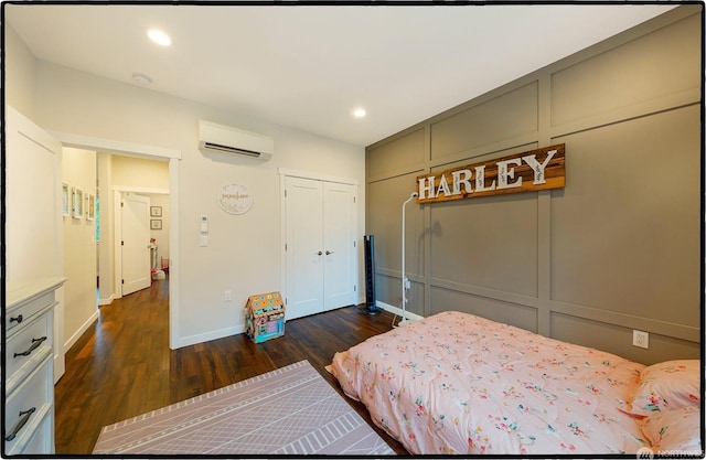 bedroom featuring dark hardwood / wood-style floors, a wall mounted air conditioner, and a closet