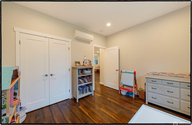 game room with dark wood-type flooring and a wall mounted air conditioner