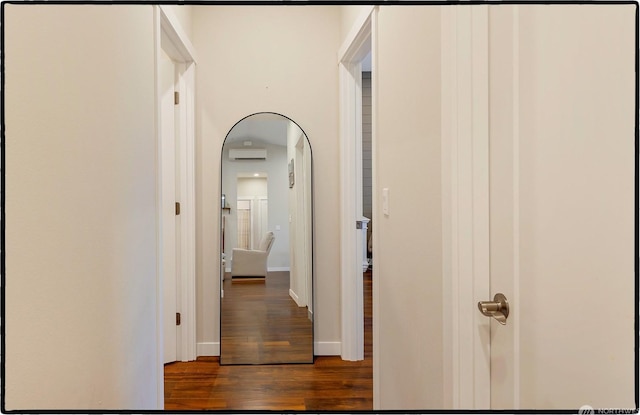 hallway with a wall mounted AC and dark hardwood / wood-style flooring