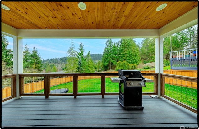 wooden terrace with a grill and a lawn