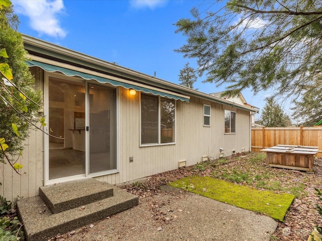 rear view of property featuring a hot tub