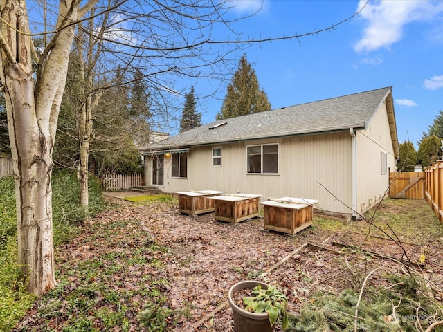 rear view of property with a hot tub and a deck