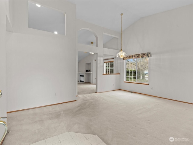 interior space with light colored carpet and high vaulted ceiling